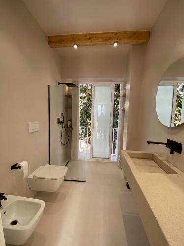 a bathroom with two sinks and a toilet and a mirror at Villa a Diamante Sulla Spiaggia in Belvedere Marittimo