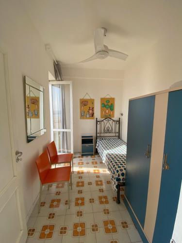 a bedroom with a bed and a chair at Villa a Diamante Sulla Spiaggia in Belvedere Marittimo