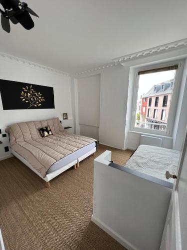 une chambre blanche avec un lit et une fenêtre dans l'établissement Appartement hyper centre Perros-Guirec, à Perros-Guirec