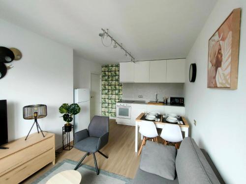 a living room with a couch and a kitchen at Second Home Arzúa apartamentos in Arzúa