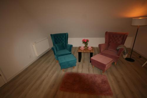 a living room with two chairs and a table at Leśniczówka Grabczok in Grabczak