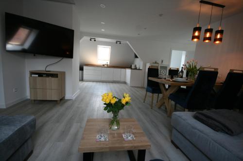 a living room with a vase of flowers on a table at Leśniczówka Grabczok in Grabczak