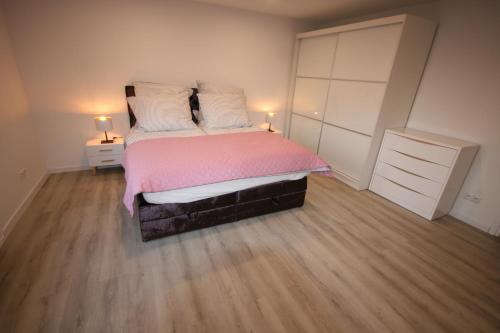 a bedroom with a bed with pink sheets and white pillows at Leśniczówka Grabczok in Grabczak
