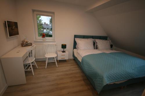 a bedroom with a bed and a desk and a window at Leśniczówka Grabczok in Grabczak