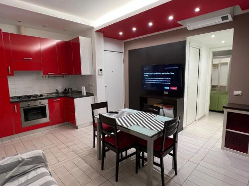 a kitchen with red cabinets and a table and chairs at Al Piano 2 in Ancona