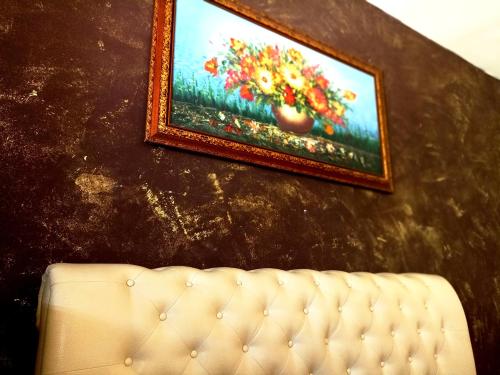 a painting on a wall next to a couch at Le Casette casa vacanze in Parabita
