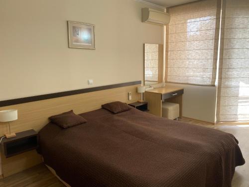 a bedroom with a large bed and a window at First Line Apartment at Obzor in Obzor