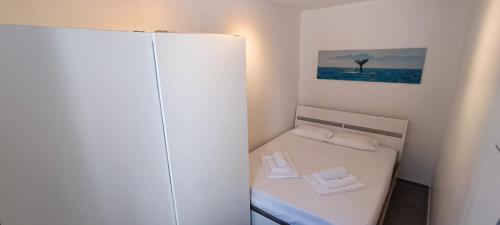 een kleine kamer met een bed met twee handdoeken erop bij Apartment Tena in Novalja