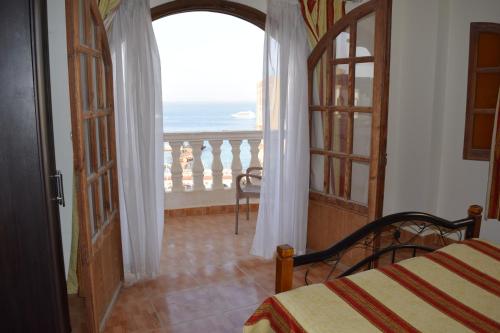1 dormitorio con cama y vistas al océano en absolute sea view flatS, en Hurghada