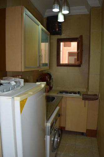 una pequeña cocina con fregadero y nevera. en absolute sea view flatS, en Hurghada