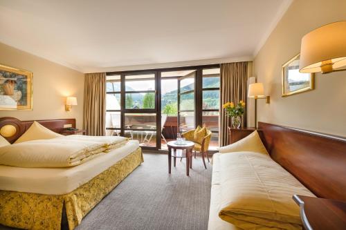 a hotel room with two beds and a couch at Familienhotel Sonngastein in Bad Gastein