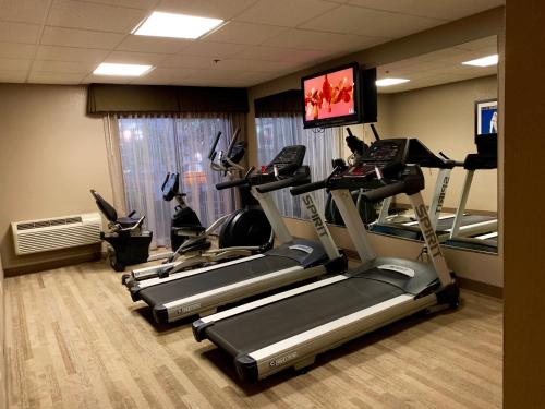 a gym with several tread machines in a room at The Academy Hotel Colorado Springs in Colorado Springs