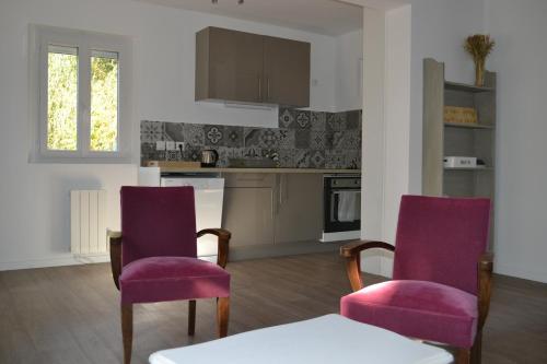 ein Wohnzimmer mit 2 Stühlen und eine Küche in der Unterkunft Sologne - Maison indépendante au cœur des châteaux in Cheverny