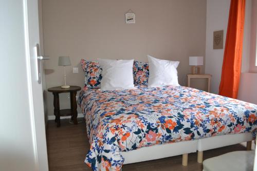 ein Schlafzimmer mit einem Bett mit einer bunten Bettdecke in der Unterkunft Sologne - Maison indépendante au cœur des châteaux in Cheverny