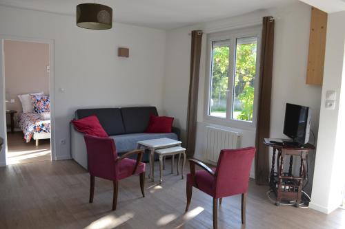 ein Wohnzimmer mit einem Sofa, Stühlen und einem Tisch in der Unterkunft Sologne - Maison indépendante au cœur des châteaux in Cheverny