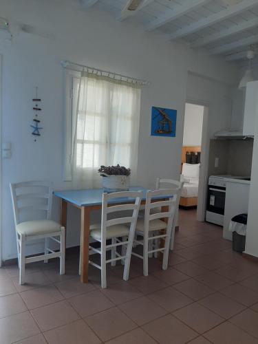 a dining room with a blue table and chairs at Chaniotis Studios in Kalafatis