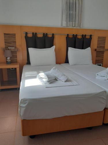 a large bed with two towels on top of it at Chaniotis Studios in Kalafatis