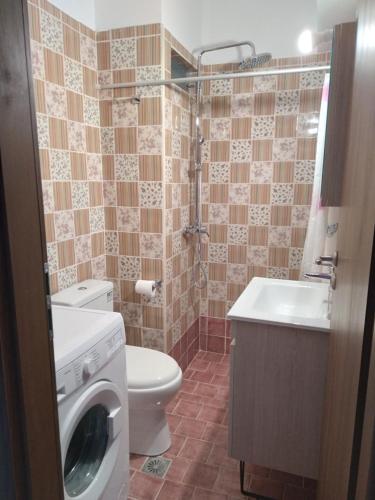 a bathroom with a toilet and a washing machine at Eliza Apartments in Rethymno Town