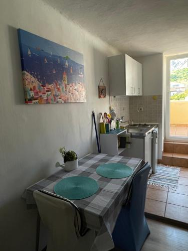 a kitchen with a table with green plates on it at Apartments Luna in Baška