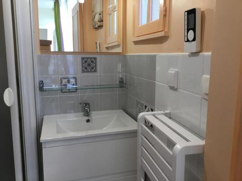 a bathroom with a sink and a bath tub at Au Bon Gite - Studio in Arromanches-les-Bains