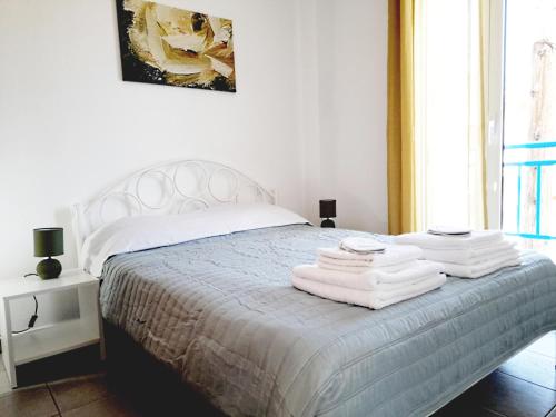 Un dormitorio con una cama blanca con toallas. en Kallithea Central Residence, en Kallithea Halkidikis