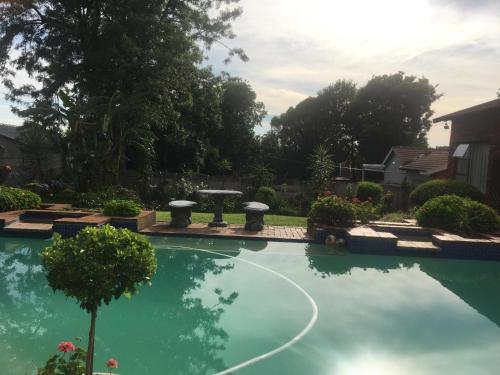 a swimming pool in a yard with a fountain at Rest Assured in Roodepoort