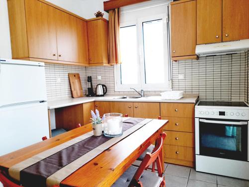 cocina con armarios de madera y mesa de madera en Kallithea Central Residence, en Kallithea Halkidikis