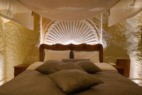 a bedroom with a large bed with a fancy ceiling at Fairyland Cave Hotel in Goreme