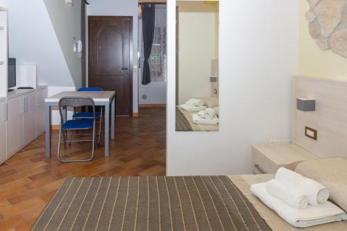 カメラーノにあるLa Piana Affittacamereのベッド1台付きの部屋、テーブル付きのキッチンが備わる客室です。