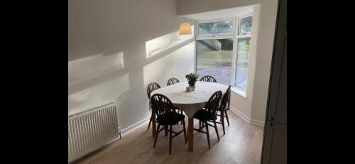 una sala da pranzo con tavolo, sedie e una finestra di Peaceful cottage with fireplace Charleton Estate a Elie