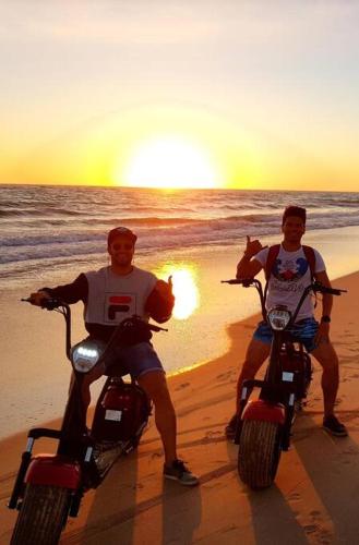 two men on motor scooters on the beach at sunset at Gran Calahonda Beach near Marbella in Málaga