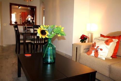 a living room with a vase with flowers on a table at Gran Calahonda Beach near Marbella in Málaga