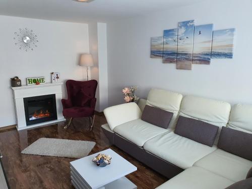 a living room with a white couch and a fireplace at Seaside Home Apartment in Mangalia