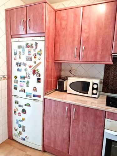 a kitchen with a white refrigerator and a microwave at Gran Calahonda Beach near Marbella in Málaga