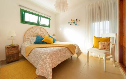 a bedroom with a bed and a chair at Delightful front beach apartment. Sunrise views! in Playa del Aguila