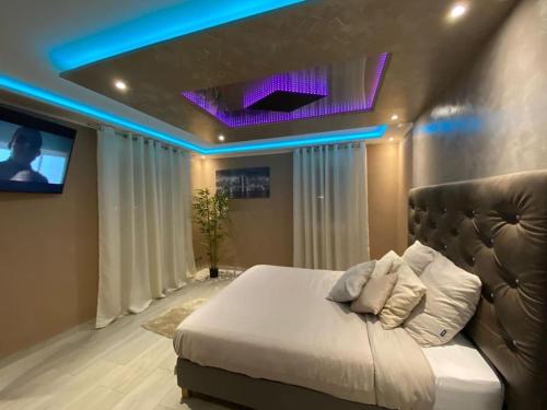 sypialnia z dużym łóżkiem z telewizorem w obiekcie RoyalSpa appartement d'amour avec jacuzzi privatif w Strasburgu