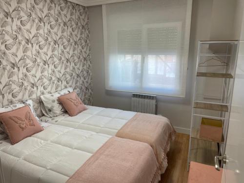 a bedroom with a large white bed with pink pillows at Apartamento Cuatro Estaciones VT-LR1404 in Calahorra