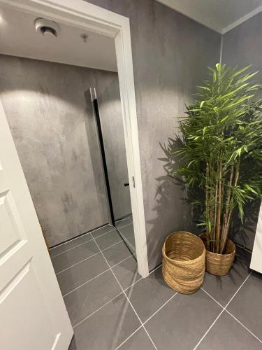 a bathroom with two potted plants next to a door at Lødingen Brygge in Lødingen