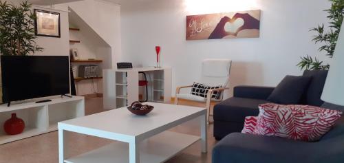 a living room with a blue couch and a tv at Lovely new House - Guests Apartments in Olhão