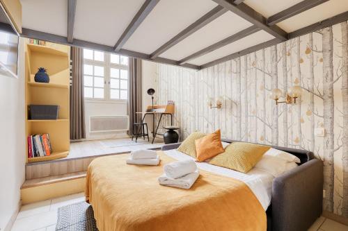 une chambre avec un grand lit avec deux serviettes dessus dans l'établissement Unique Parisian Loft at the Classy St Germain, à Paris