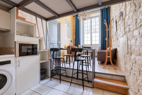 une cuisine avec une table et des tabourets dans une pièce dans l'établissement Unique Parisian Loft at the Classy St Germain, à Paris
