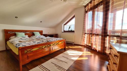 a bedroom with a bed and a large window at Clara Valis - Village House in Doľany