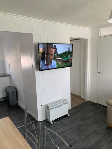 a room with a flat screen tv on a wall at Bulldog holidays 243 in Hemsby