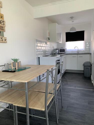 a kitchen with a wooden table and chairs at Bulldog holidays 243 in Hemsby