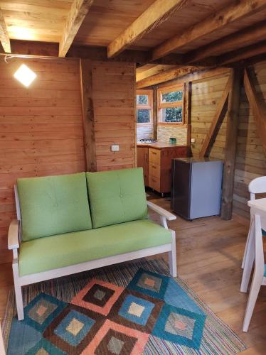 a living room with a green couch in a cabin at La Cabaña de Huckleberry in El Retiro