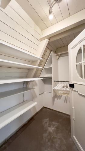 a walk in closet with white shelves and a window at Gemütliche Maisonettewohnung mit Dachterrasse am Schloß in Oldenburg