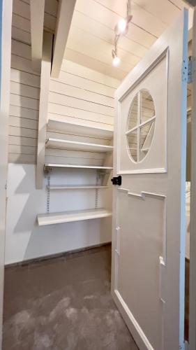 a walk in closet with a door and shelves at Gemütliche Maisonettewohnung mit Dachterrasse am Schloß in Oldenburg