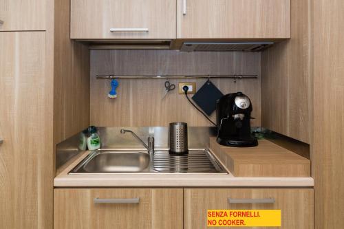 a kitchen with a sink and a microwave at La Piana Affittacamere in Camerano