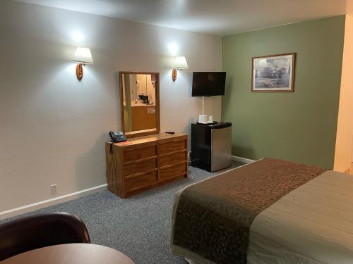 Pokój hotelowy z łóżkiem i lustrem w obiekcie Murphey's Motel LLC w mieście Lee Vining