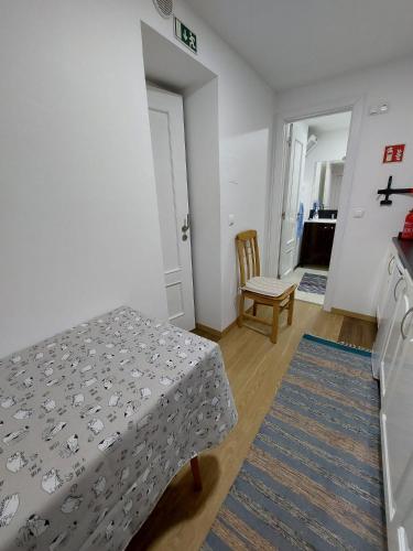 a bedroom with a bed and a chair in it at casa da fajã in Funchal